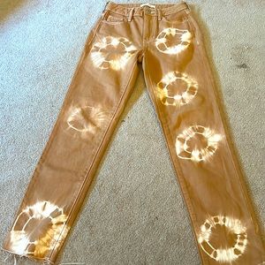Tan colored mom jean with design.